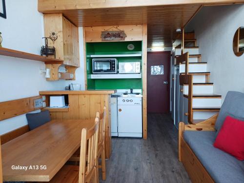 - une cuisine et une salle à manger avec une table dans une petite maison dans l'établissement Studio mezzanine cosy pour 5 aux Arcs 1800 avec Wifi proche des pistes - FR-1-411-639, à Arc 1800