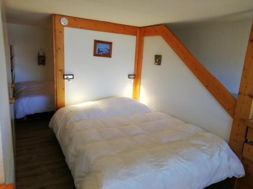 une chambre avec un grand lit blanc dans une pièce dans l'établissement Studio mezzanine cosy pour 5 aux Arcs 1800 avec Wifi proche des pistes - FR-1-411-639, à Arc 1800
