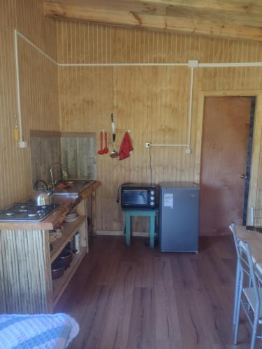 a small kitchen with a sink and a refrigerator at Cabaña bellavista in Cochamó