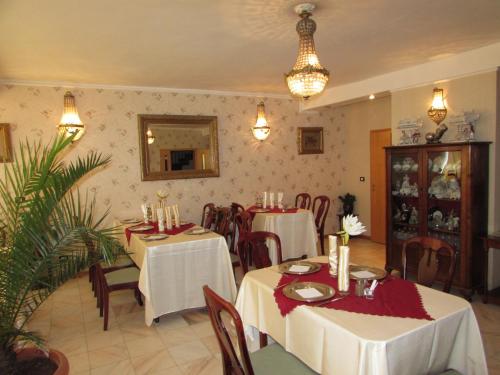 a dining room with tables and chairs in a restaurant at Pension Dinu Residence in Timişoara