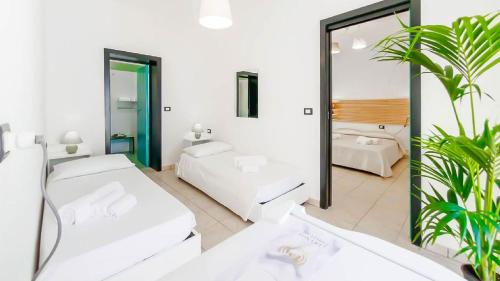 um quarto branco com 2 camas e um espelho em Lamanna's Hotel Club em Castro di Lecce
