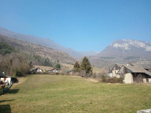 um campo com casas e uma montanha ao fundo em Le St Jean Bis em Saint-Jean-de-la-Porte
