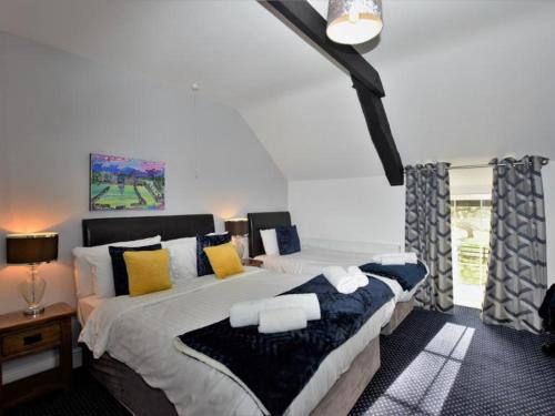 a bedroom with a large bed with yellow and blue pillows at Aberystwyth, Pentre Farmhouse, in Capel Bangor