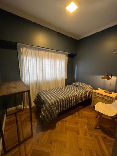 sypialnia z łóżkiem, stołem i oknem w obiekcie Habitaciones Garay 3100 w mieście Mar del Plata