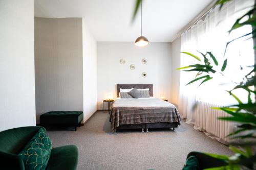 - une chambre avec un lit et deux chaises vertes dans l'établissement Central Square Apartments, à Belgrade