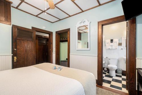 1 dormitorio con 1 cama y baño con aseo en Historic Hotel Nichols en South Haven