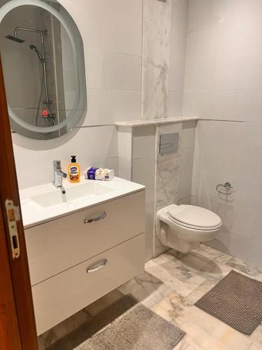 een badkamer met een toilet, een wastafel en een spiegel bij LUXURY APPART Pool view Riad Garden in Marrakesh