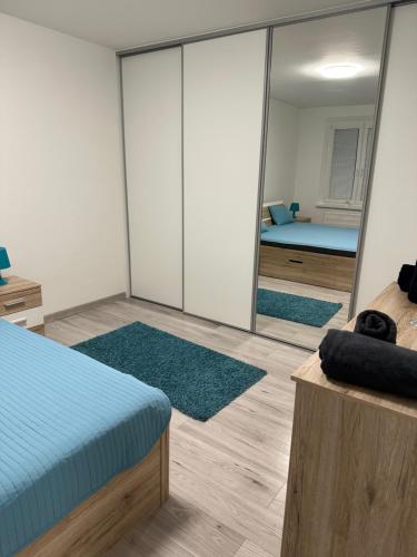 Dormitorio con paredes de espejo, cama y espejo en Útulný byt Brezno v Nízkych Tatrách, en Brezno