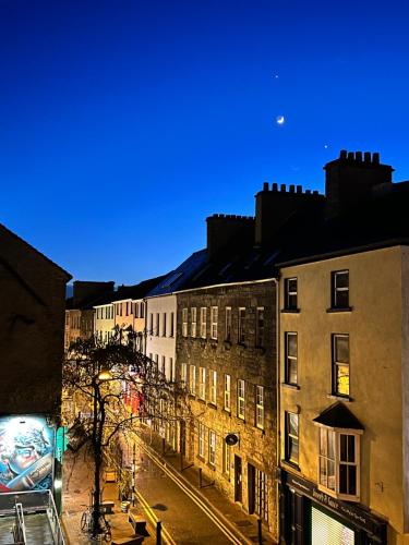 un grupo de edificios en una calle de la ciudad por la noche en Buttermilk Walk Room en Galway