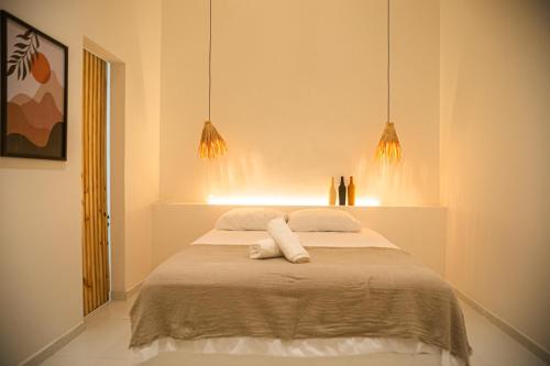 een slaapkamer met een bed met twee handdoeken erop bij Casa privativa na Vila Ser tão zen #02 in Tibau do Sul