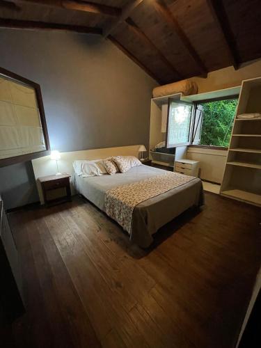 1 dormitorio con 1 cama y 2 ventanas en Cabaña Bosque Peralta Ramos en Mar del Plata