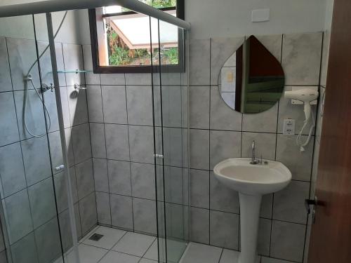 W łazience znajduje się umywalka i przeszklony prysznic. w obiekcie Curral Beach w mieście Ilhabela