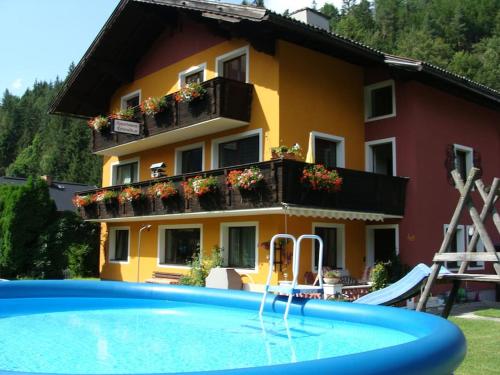 a building with a swimming pool in front of a house at Appartement-Reiteralm Schober in Schladming