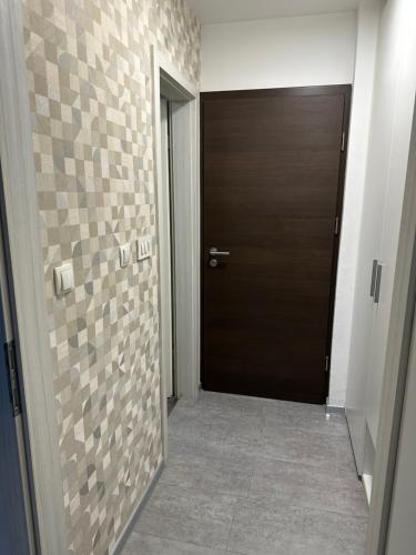 a hallway with a door and a tile wall at Apartments Kaninska Vas in Bovec