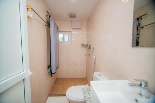 a bathroom with a white toilet and a sink at Majheri Resort and Spa in Pokhara