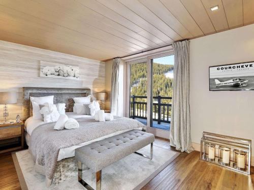 une chambre avec un grand lit et une grande fenêtre dans l'établissement Chalet de luxe avec jacuzzi et garage à Courchevel - FR-1-563-30, à Courchevel