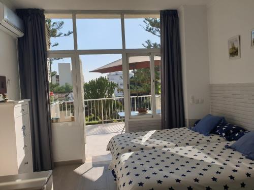 een slaapkamer met een bed en een glazen schuifdeur bij Carihuela Park Palace Studio in Torremolinos