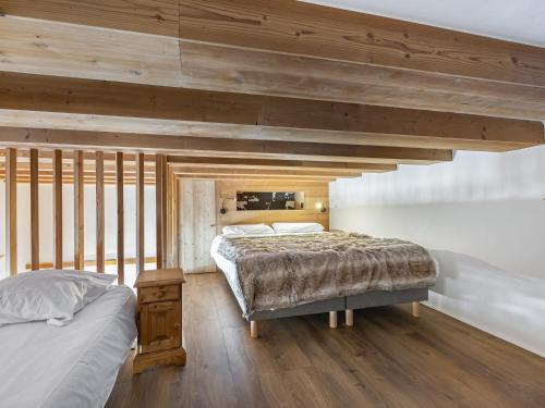 two beds in a bedroom with wooden ceilings at Appartement Courchevel 1650, 2 pièces, 5 personnes - FR-1-563-70 in Courchevel