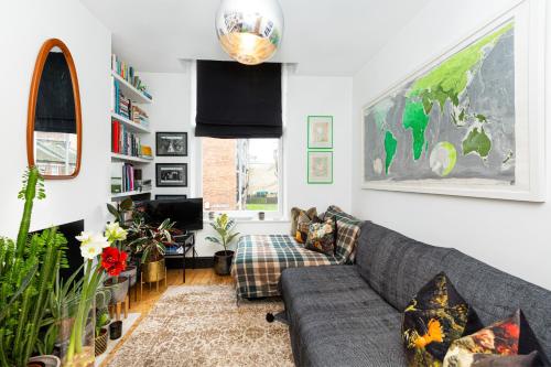 ein Wohnzimmer mit einem Sofa und einem TV in der Unterkunft Unique stylish 1BR flat near Columbia Road in London