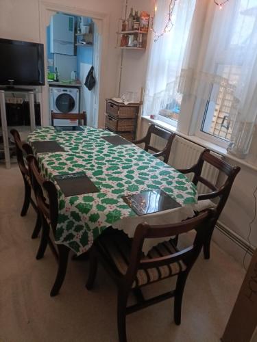 a dining room table with a green and white table cloth at Alysguesthub in London