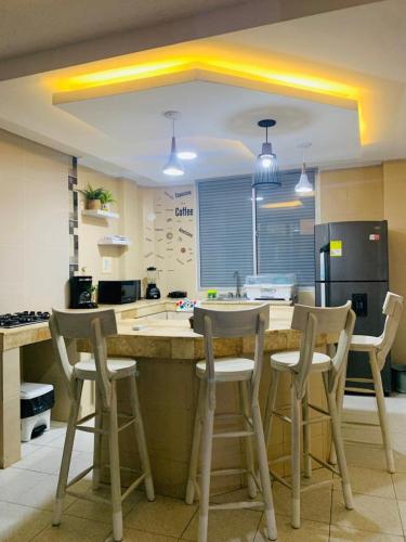 a kitchen with a counter and stools in a kitchen at Cabaña 8 Arrecifes in Coveñas