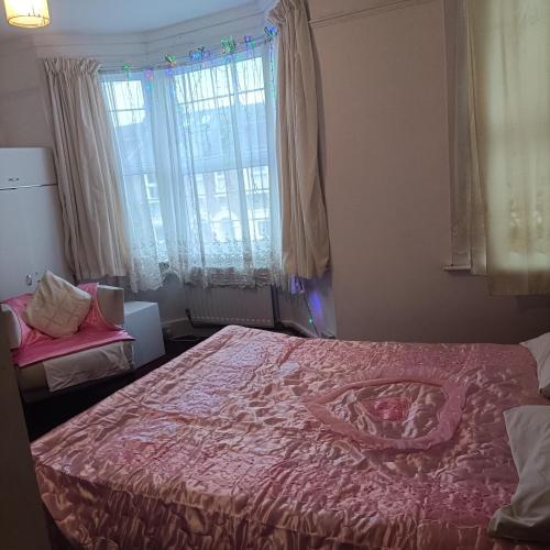 a bedroom with a large bed and a window at Alysguesthub in London