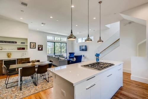 a kitchen and living room with a table and chairs at 4 Story Modern Home Sleeps 10 - DT Views! in Houston