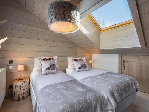 Duas camas num pequeno quarto com uma clarabóia. em Appartement Méribel, 4 pièces, 6 personnes - FR-1-565-23 em Les Allues