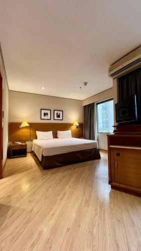 a large bedroom with a bed and a television at Suíte Transamerica Executive Paulista in Sao Paulo