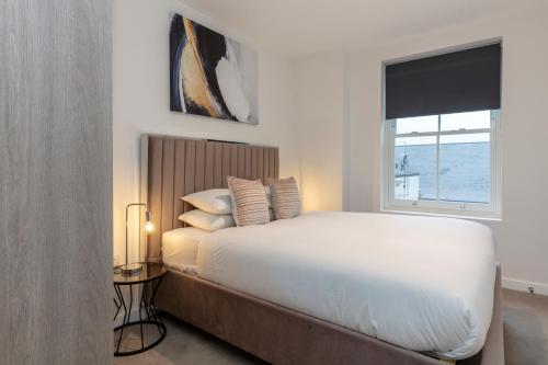 a bedroom with a white bed and a window at Deluxe North Central London Apartment in London