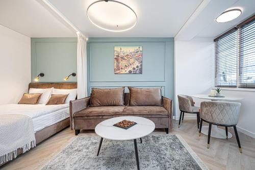 a bedroom with a bed and a couch and a table at A&I city view apartment in Vilnius