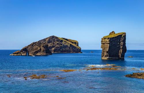 モステイロスにあるWelcomeBuddy - Villa Mar Azul - Mosteiros Beachの大岩を持つ海の島