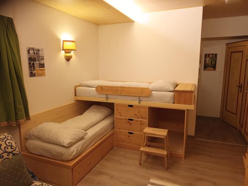 a room with two bunk beds and a desk at De Prealon Apartment in Moena