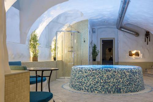 a room with a shower with a table and chairs at Kurpiai - Suites & SPA in Klaipėda