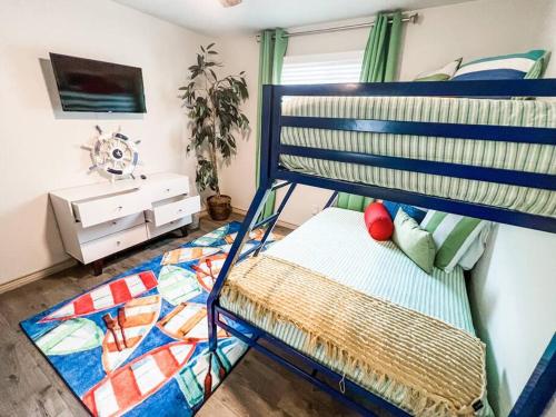 a bedroom with a bunk bed with a bedspread at Nautical Retreat (Unit 5) in Galveston