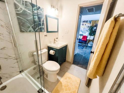 a bathroom with a toilet and a glass shower at Nautical Retreat (Unit 5) in Galveston