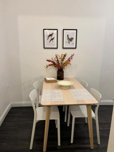 une table en bois avec des chaises et un vase avec des fleurs dans l'établissement CASA AUGUSTO, à Trieste