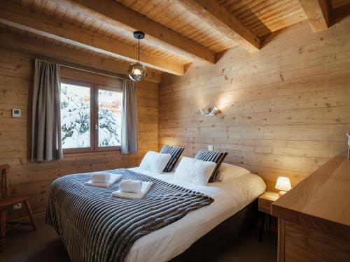 une chambre avec un lit dans une pièce en bois dans l'établissement Chalet rénové 2020 pour 8 pers., proche pistes et village, garage, WIFI – La Clusaz - FR-1-304-262, à La Clusaz