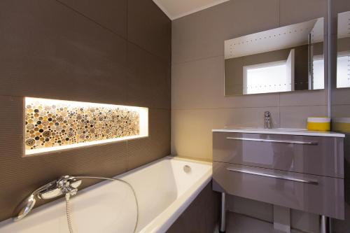 une salle de bain avec une baignoire et un lavabo dans l'établissement 2-Br apartment 2 minutes from the beach parking, à Cannes