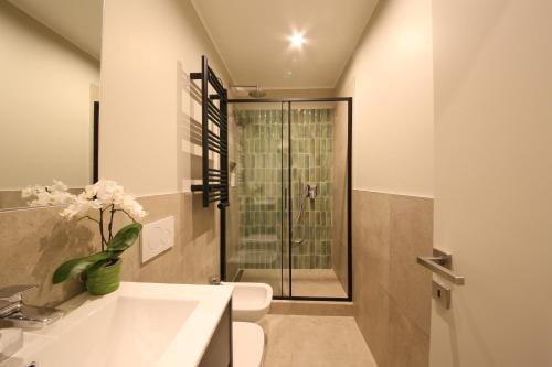een badkamer met een toilet, een wastafel en een douche bij Meyland suites centro in Milaan
