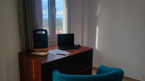a desk with a laptop and two chairs in a room at Maisonette Kavousi with Mountain and Village View in Kavoúsion