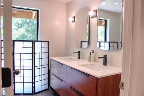 ein Badezimmer mit zwei Waschbecken und zwei Spiegeln in der Unterkunft Charming Scandinavian Modern Riverfront Fishhouse in Hailey