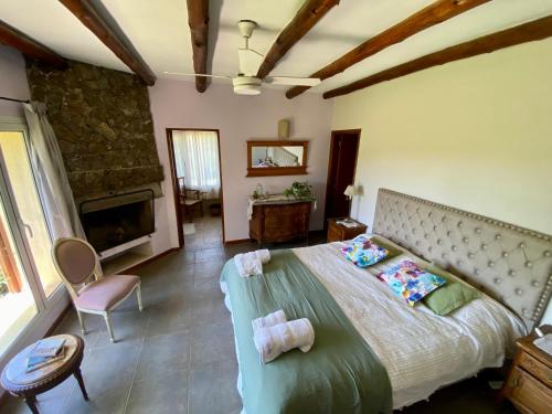 a bedroom with a large bed and a fireplace at Posada Sausalito in Santa Rosa de Calamuchita