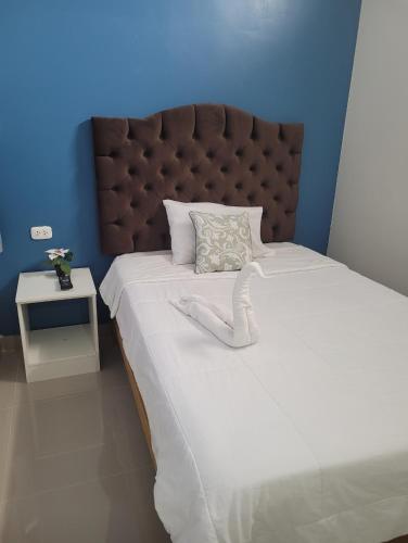 um quarto com uma cama grande e uma cabeceira castanha em CASA MARIA em Pisco