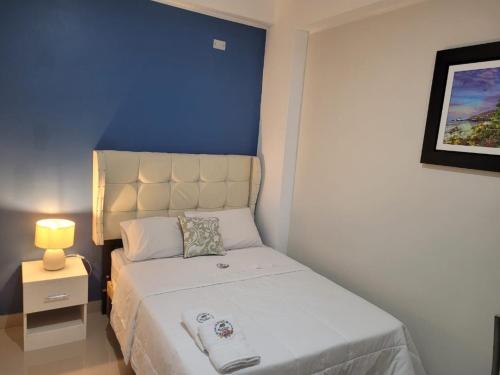 um pequeno quarto com uma cama com uma parede azul em CASA MARIA em Pisco
