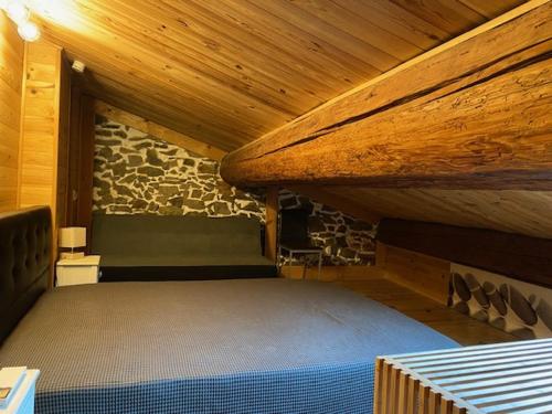 un lit dans une chambre avec un mur en pierre dans l'établissement Le charme de Collioure, à Collioure