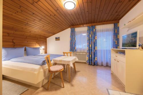 1 dormitorio con 1 cama, mesa y sillas en Haus Gerlinde Danler, en Neustift im Stubaital