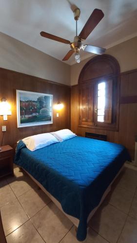 sypialnia z niebieskim łóżkiem i wentylatorem sufitowym w obiekcie Cordoba Yolanda Hotel w Córdobie