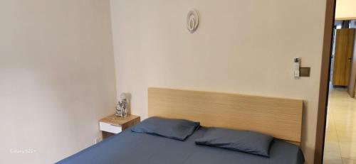 Un dormitorio con una cama con cabecero de madera. en NAYUHA apt B, en Flic en Flac