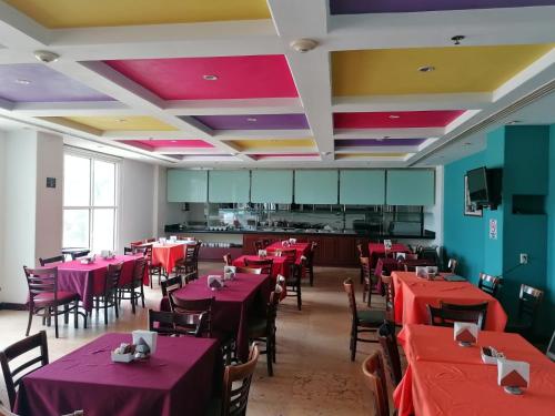 un restaurante con mesas y sillas rojas y una cocina en Sierra Huasteca Inn en Ciudad Valles